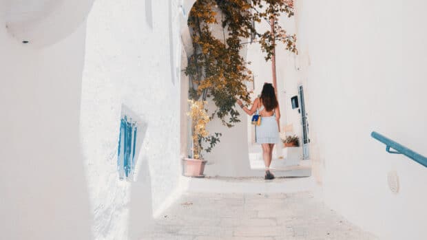 Viajera caminando por los callejones blancos de Grecia